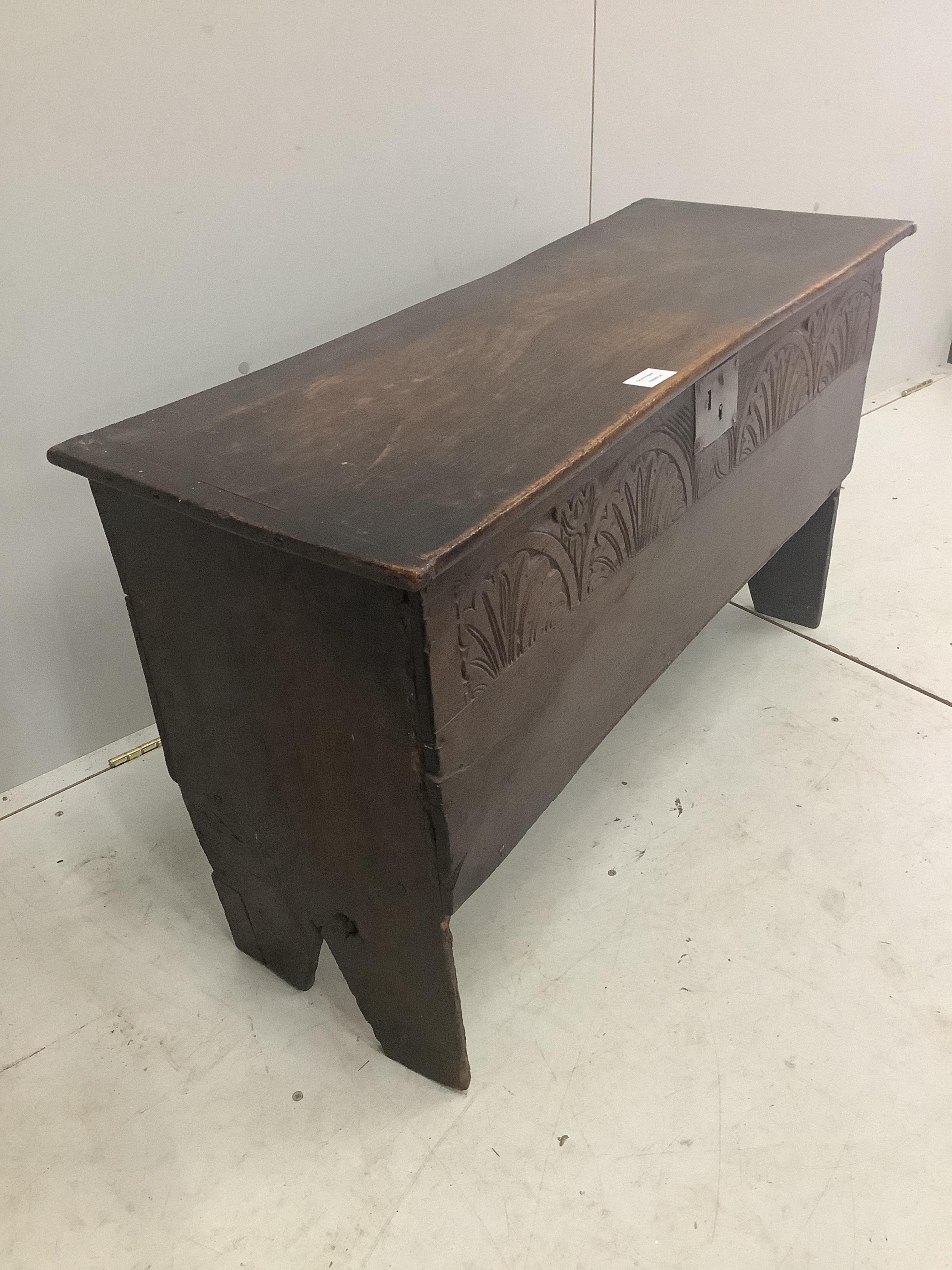 An early 18th century oak six plank coffer, with a lunette carved front, width 103cm, depth 38cm, height 61cm. Condition - fair